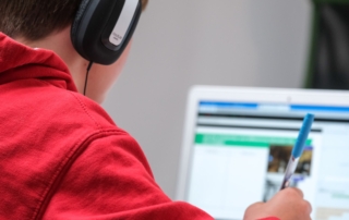 person in red shirt wearing black and gray headphones