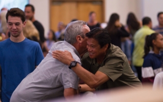 two men hugging on focus photography