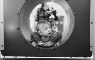 grayscale photo of child in hole