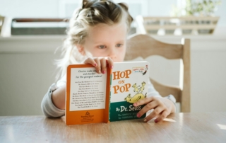 girl sitting while reading book