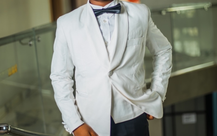 A young boy in a white suit and bowtie